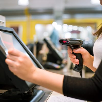 Young woman hand doing process payment on a touchscreen cash register, finance concept